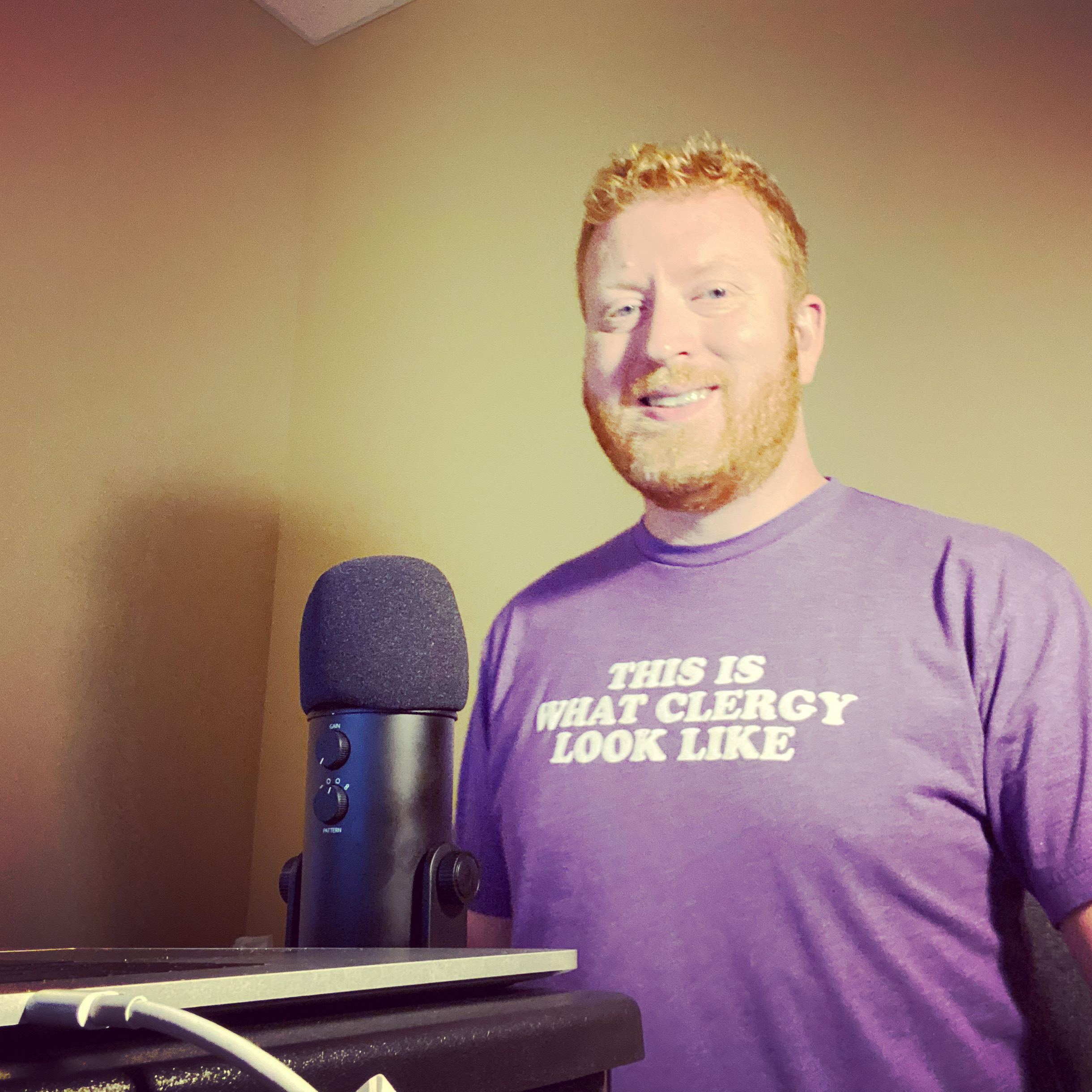 Matthew Redrich, red hair and beard, at a podcast microphone